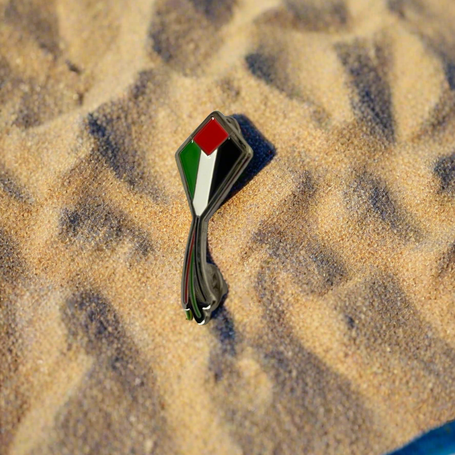 Pin with Palestinian flag design on sand